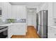 Well-appointed kitchen with stainless steel refrigerator, sleek white cabinets, and tiled backsplash for modern living at 127 Oxford Dr, Mooresville, NC 28115