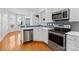 Stylish kitchen featuring stainless steel appliances, white cabinetry, and a view to the breakfast nook at 127 Oxford Dr, Mooresville, NC 28115