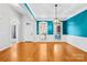 Bright living room featuring hardwood floors, a modern light fixture, and distinctive turquoise wall accents at 127 Oxford Dr, Mooresville, NC 28115