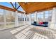 Sunroom features a wooden beamed ceiling, multiple windows, and a bed swing with pillows at 127 Oxford Dr, Mooresville, NC 28115