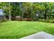 A green backyard with a wooden fence and mature trees at 1322 Condon St, Charlotte, NC 28216