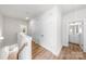 Bright hallway with a bathroom and closet access, featuring hardwood floors and crisp, white doors at 1322 Condon St, Charlotte, NC 28216