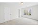 Bright bedroom featuring a large window and neutral carpet, offering a serene and inviting space at 13514 Porter Creek Rd, Charlotte, NC 28262