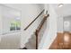 Carpeted staircase with wooden handrail leads to the upper level of the home at 13514 Porter Creek Rd, Charlotte, NC 28262