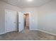 A spacious carpeted bedroom with open closet and white doors provides a calming retreat at 1814 Shumard Ln, Charlotte, NC 28205