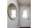 Inviting foyer with white door, transom window, wood floors, and a stylish round mirror at 1814 Shumard Ln, Charlotte, NC 28205