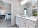 This main bathroom features double sinks, quartz countertops, white cabinets, and a view into the main bedroom at 1814 Shumard Ln, Charlotte, NC 28205