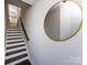 Staircase with dark wood treads, white risers, dark railing, and a stylish round mirror at 1814 Shumard Ln, Charlotte, NC 28205