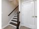 Carpeted stairwell with dark-stained wood steps and a white door at 1814 Shumard Ln, Charlotte, NC 28205