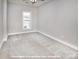 Bright, carpeted bedroom featuring neutral walls, white trim, and a window allowing ample natural light at 19724-A School St, Cornelius, NC 28031