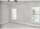 Spacious bedroom featuring neutral walls, white trim, carpeted flooring, and natural light from two windows at 19724-A School St, Cornelius, NC 28031