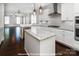 Modern kitchen with white cabinets, stainless steel appliances, granite countertops, and center island at 19724-A School St, Cornelius, NC 28031
