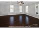 Bright living room featuring hardwood floors, large windows, and a ceiling fan at 19724-A School St, Cornelius, NC 28031