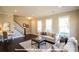 Spacious living room with large windows, fireplace, and access to a stylish staircase at 19724-A School St, Cornelius, NC 28031