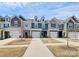 Street view of modern townhomes showcasing individual garages and unique facades at 2707 Aubrey St, Monroe, NC 28110