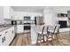 Kitchen featuring white cabinets, granite countertops, stainless steel appliances, island with breakfast bar, and wood floors at 2707 Aubrey St, Monroe, NC 28110