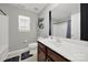 A well-lit bathroom featuring a large mirror, white fixtures, and a decorative shelf at 311 Glenn Allen Rd, Mooresville, NC 28115