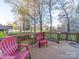 Wood deck with red adirondack chairs and a view of the large grassy backyard at 3229 Leicester Dr, Matthews, NC 28104