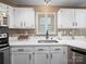 Well-lit kitchen with stainless steel appliances, white cabinets, and a decorative backsplash at 3229 Leicester Dr, Matthews, NC 28104