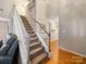 Bright staircase with carpeted steps, white railings, and hardwood floors on the landing at 3229 Leicester Dr, Matthews, NC 28104