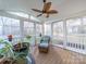 Bright sunroom with comfortable seating, a ceiling fan, and views of the surrounding greenery at 3229 Leicester Dr, Matthews, NC 28104