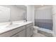 Well-lit bathroom featuring a double sink vanity with gray cabinets and a shower with a patterned gray curtain at 3309 Colorado Blue Ct, Gastonia, NC 28056