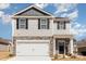 Inviting two-story home with stone facade, attached garage, and manicured front lawn under blue skies at 3309 Colorado Blue Ct, Gastonia, NC 28056