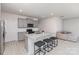 Well-lit kitchen featuring gray cabinets, granite counters, stainless appliances, and breakfast bar at 3309 Colorado Blue Ct, Gastonia, NC 28056