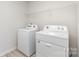 Functional laundry room equipped with modern washer and dryer, and overhead shelving at 3309 Colorado Blue Ct, Gastonia, NC 28056