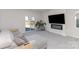 Bright living room features an electric fireplace, flatscreen tv, gray sectional and multiple plants at 3309 Colorado Blue Ct, Gastonia, NC 28056