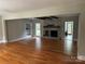 Spacious living room with a stone fireplace, wooden beams, hardwood floors, and built in shelving at 3424 Red Fox Trl, Matthews, NC 28104