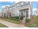 Charming townhome with grey siding, a covered front porch, and mature landscaping at 4102 Harmony Hills Dr, Matthews, NC 28104