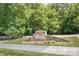 Squirrel Lake Park entrance sign with a stone base and a backdrop of mature trees and green space at 4102 Harmony Hills Dr, Matthews, NC 28104