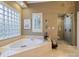 Elegant bathroom featuring a soaking tub, glass block window, and a separate glass shower at 4510 Old Course Dr, Charlotte, NC 28277