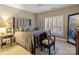 Cozy bedroom featuring a dark wood bed frame, neutral walls, and plantation shutters at 4510 Old Course Dr, Charlotte, NC 28277