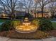 Beautifully landscaped front yard featuring a tiered fountain and mature trees at 4510 Old Course Dr, Charlotte, NC 28277