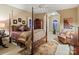 Spacious primary bedroom with four-poster bed, sitting area, and arched window at 4510 Old Course Dr, Charlotte, NC 28277