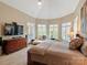 Spacious main bedroom with tray ceiling, bay windows with shutters, and a cozy chaise lounge at 4510 Old Course Dr, Charlotte, NC 28277