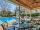 Covered patio with poolside dining and a view of the luxury home, pool, and landscaping for elegant outdoor living at 4510 Old Course Dr, Charlotte, NC 28277