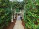 Charming walkway lined with lush greenery and white pillars leads to an inviting gated entrance, showcasing outdoor beauty at 4510 Old Course Dr, Charlotte, NC 28277