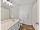 Bathroom featuring a white vanity, a large mirror, and neutral-toned tile flooring at 4634 Craigmoss Ln, Charlotte, NC 28278
