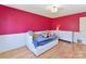 bedroom featuring a bright pink accent wall, hardwood floors, and built in drawers at 4634 Craigmoss Ln, Charlotte, NC 28278