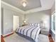 Light-filled main bedroom with a tray ceiling, carpet, and side tables at 4634 Craigmoss Ln, Charlotte, NC 28278