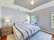 Spacious main bedroom with a tray ceiling, carpet, and natural light at 4634 Craigmoss Ln, Charlotte, NC 28278