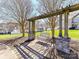 Relaxing outdoor swing set under a pergola, surrounded by mature trees and lush landscaping at 4634 Craigmoss Ln, Charlotte, NC 28278