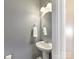 Clean powder room with pedestal sink and round mirror at 4634 Craigmoss Ln, Charlotte, NC 28278