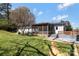 Backyard view showcasing a screened in porch with an outdoor deck and a spacious lawn at 4790 Polk Ford Rd, Stanfield, NC 28163