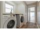 Bright laundry room with front load washer and dryer and natural light at 4790 Polk Ford Rd, Stanfield, NC 28163