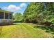 Lush backyard with manicured lawn, mature trees, and a view of the screened porch at 8008 Battersea Ct, Waxhaw, NC 28173