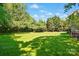 Large backyard with mature trees providing shade and a well-manicured lawn at 8008 Battersea Ct, Waxhaw, NC 28173